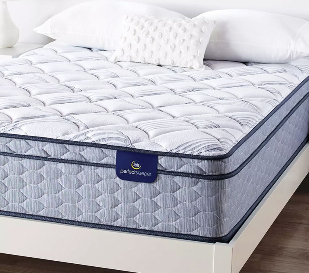 white and blue serta mattress on a white bed frame with pillows on top of the mattress