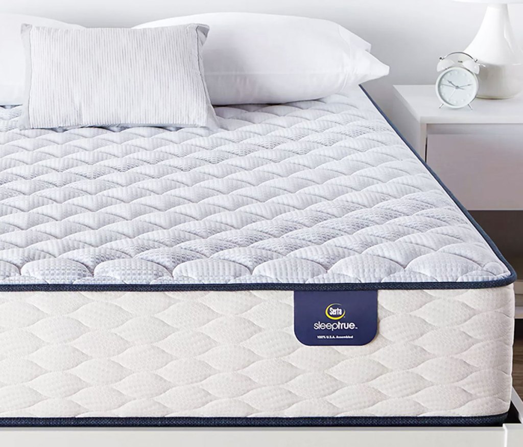 white and light blue serta mattress on a white bed frame with pillows on top of the mattress