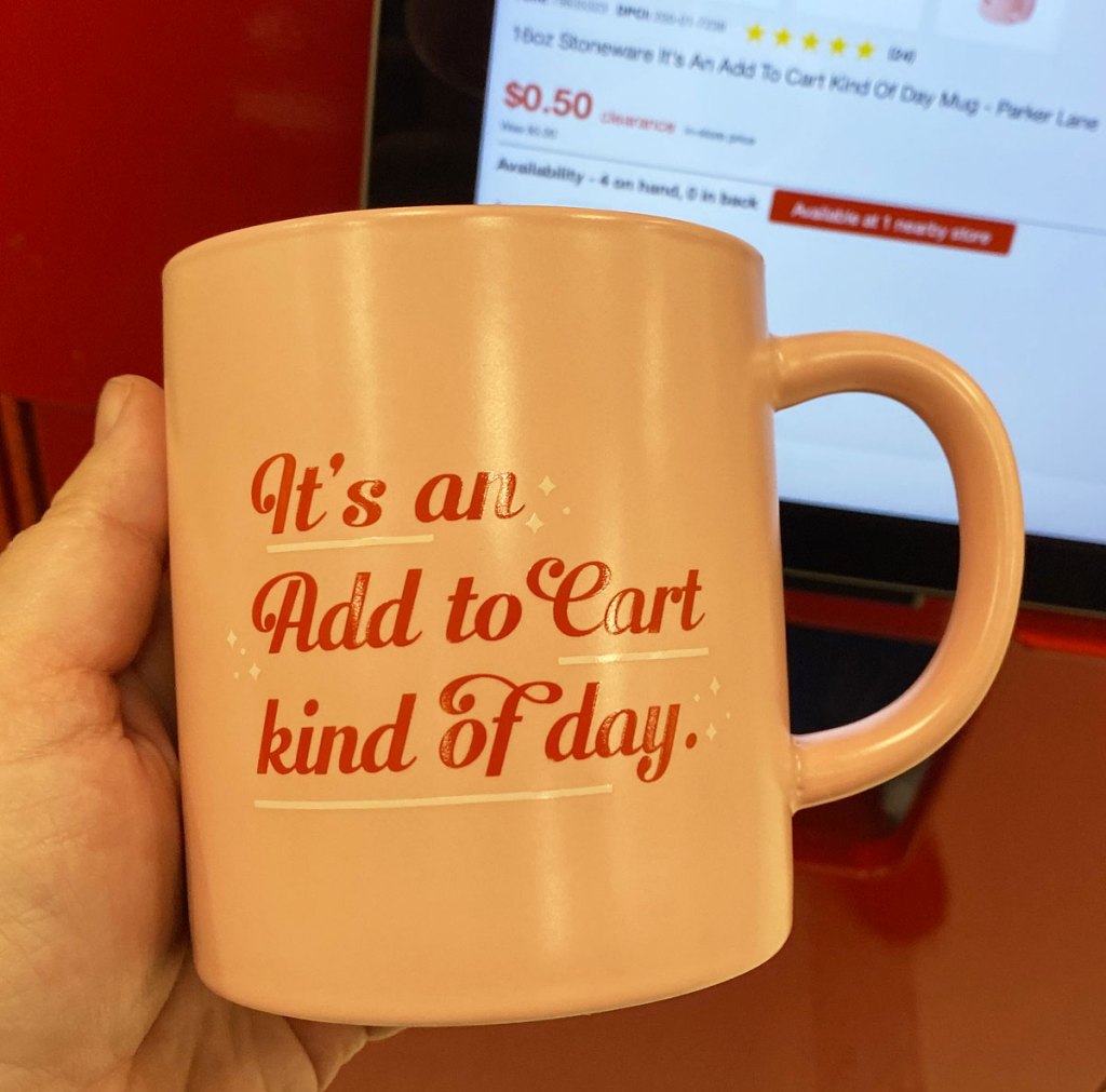 person holding up a pink coffee mug at a target price scanner