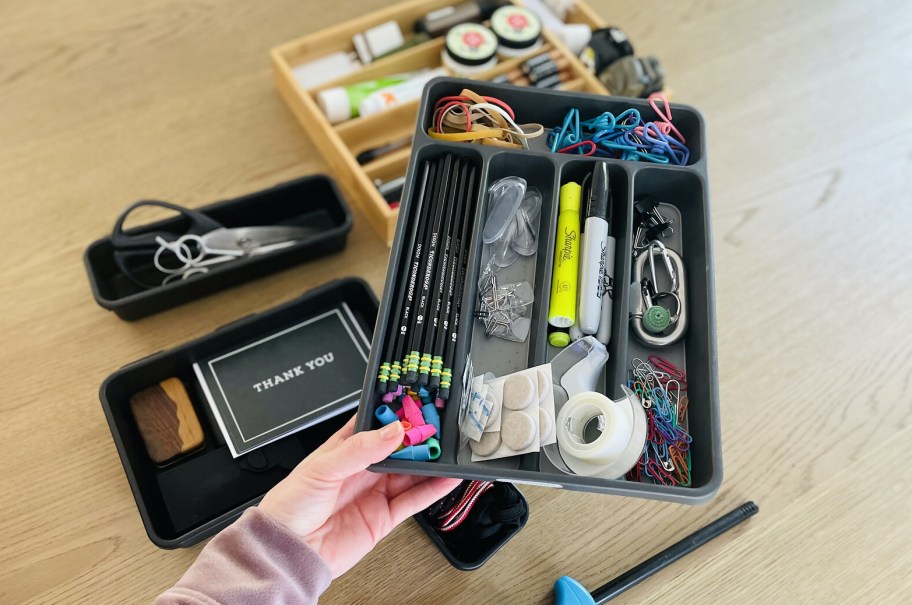 hand holding utensil organizer with stationary stuff inside