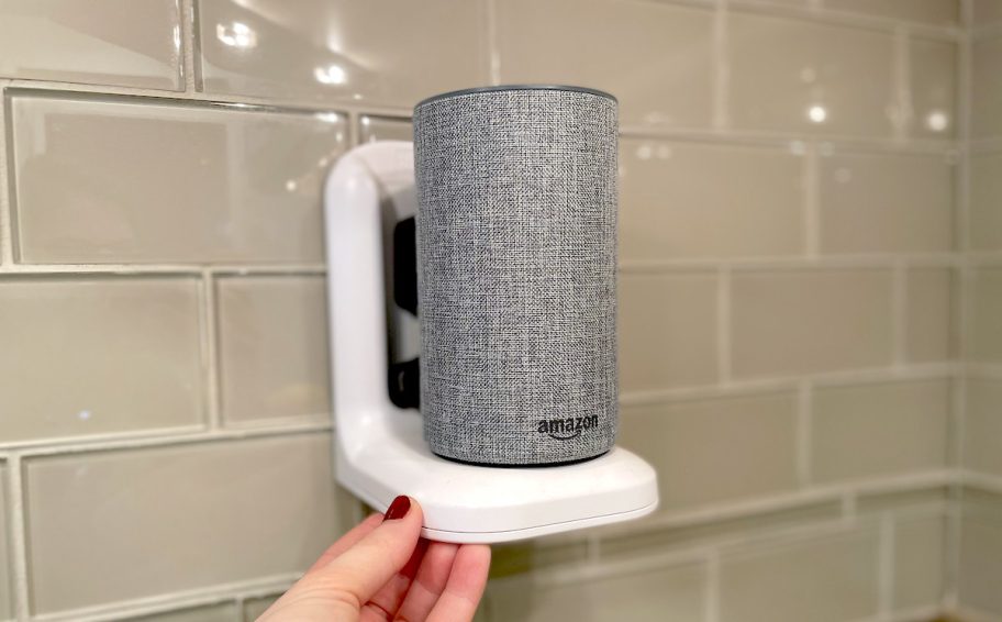 hand holding corner of white outlet shelf with amazon alexa