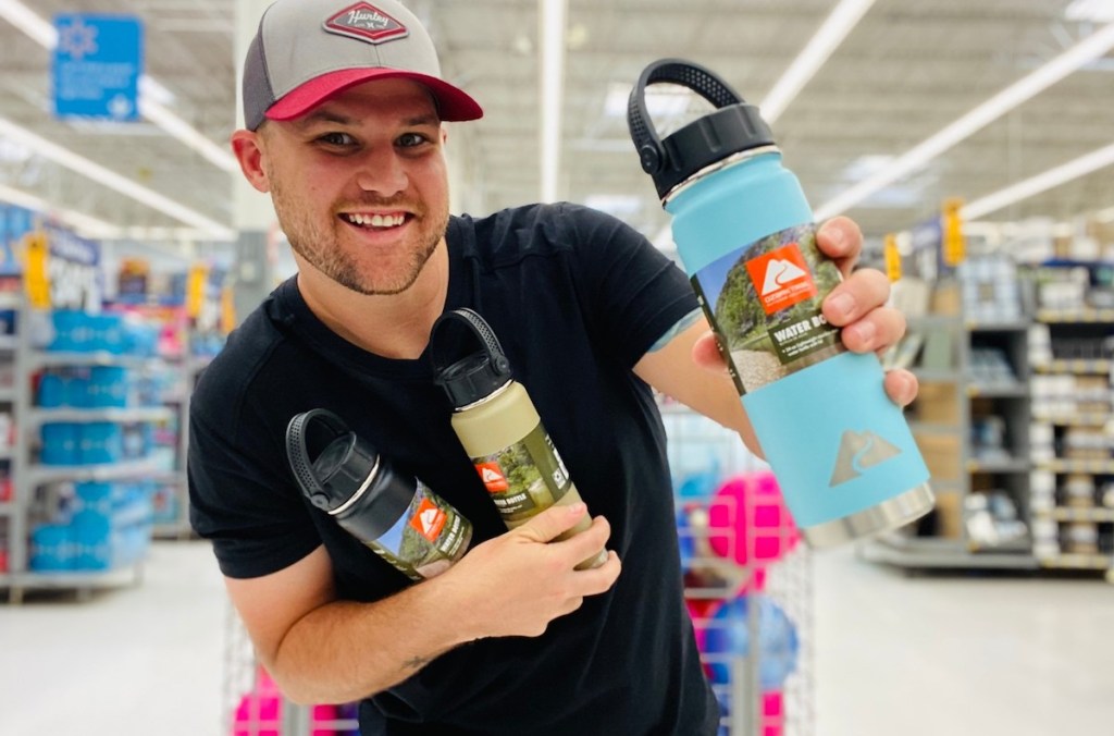 man holding up blue ozark trail water bottle in store