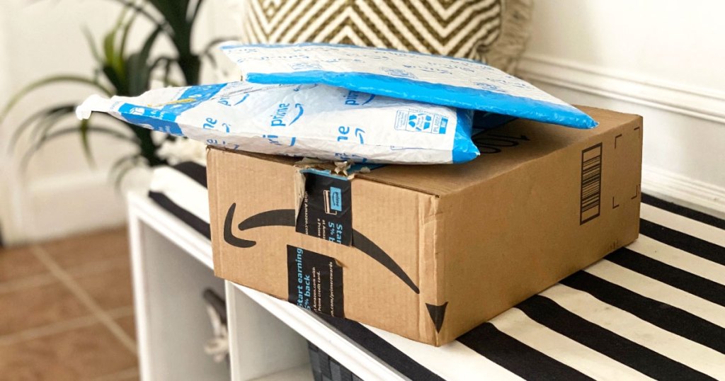 amazon boxes stacked on black and white striped bench