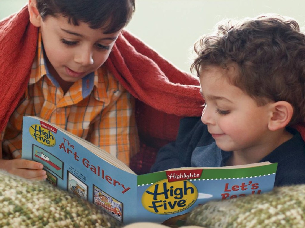 two little boys laying under a blanket reading highlights high five kids magazine