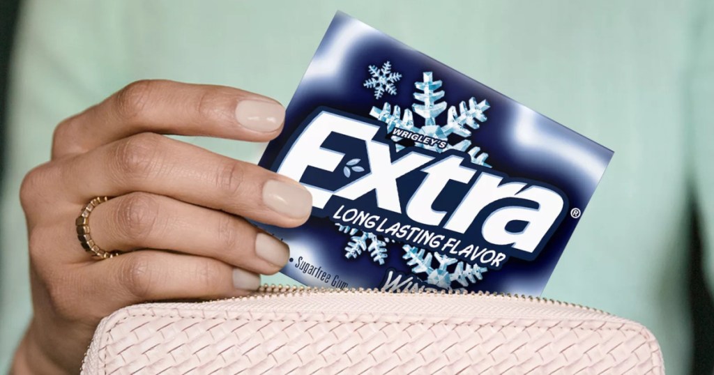 woman pulling pack of gum out of light pink bag