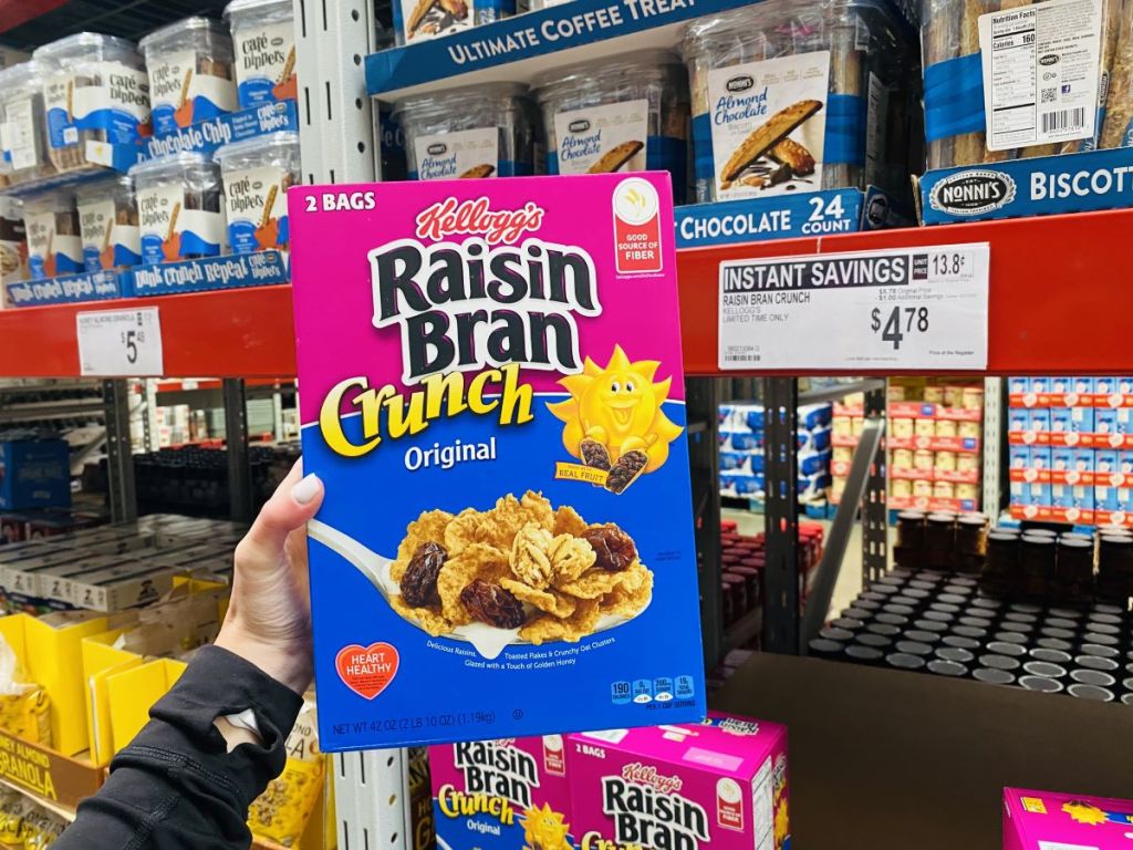 hand holding a box of Raisin Bran Crunch at Sam's Club