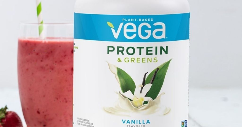 Vega Protein and Greens powder container next to a smoothie