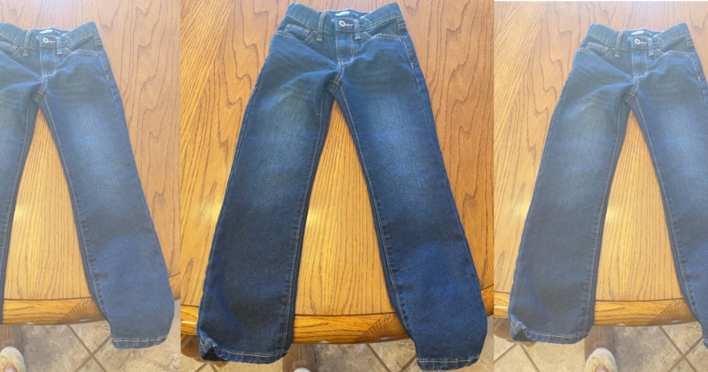 three pairs of kids jeans on wood table