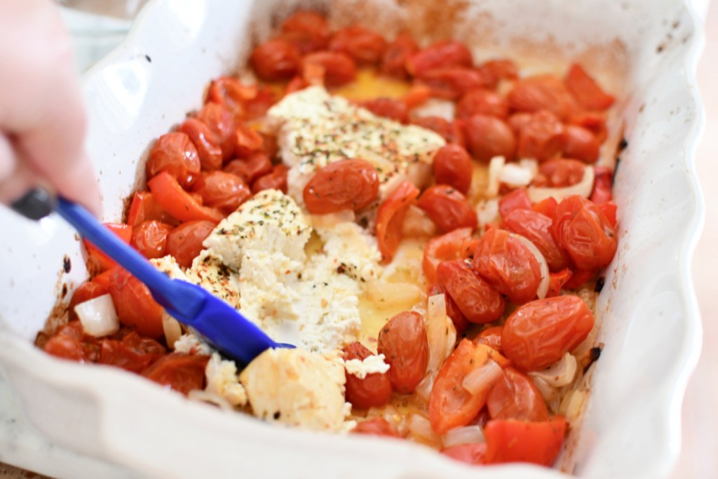 stirring melted feta and roasted tomatoes 