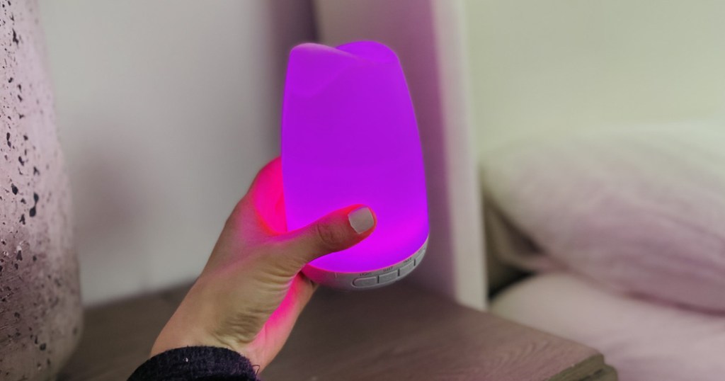 woman holding fragrance diffuser lit up purple