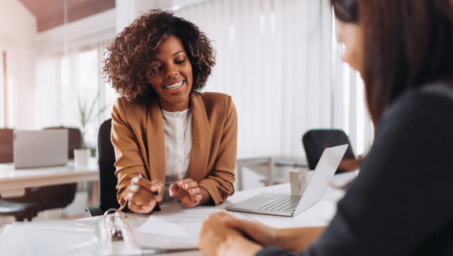 two women talking at a desk