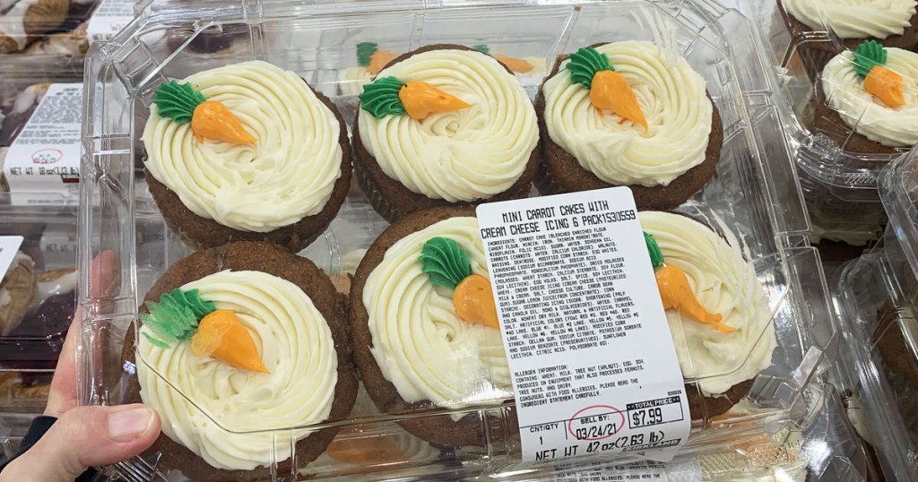 person holding package of carrot cake cupcakes at costco