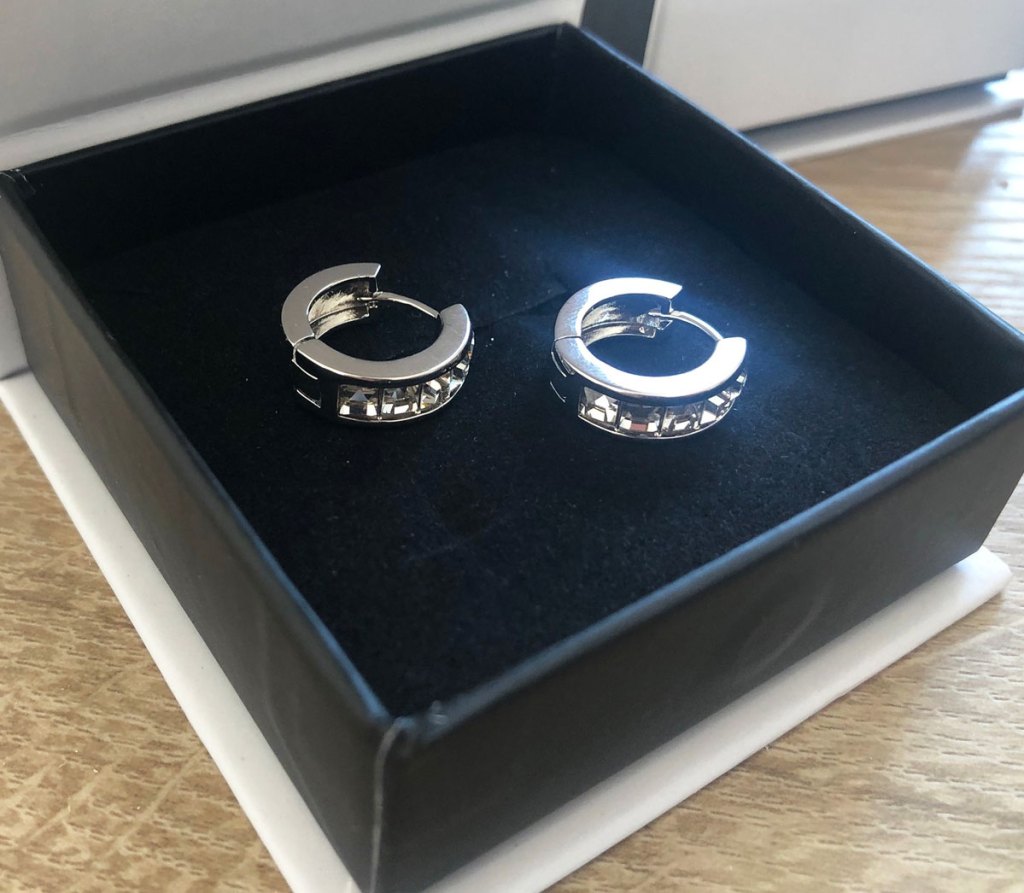 two white gold hoop earrings in black box