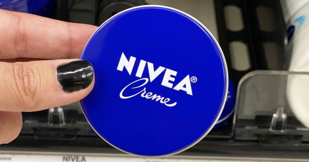 hand holding up blue nivea creme tin