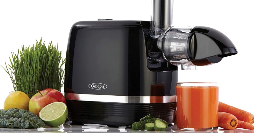 black juicer surrounded by juice and produce