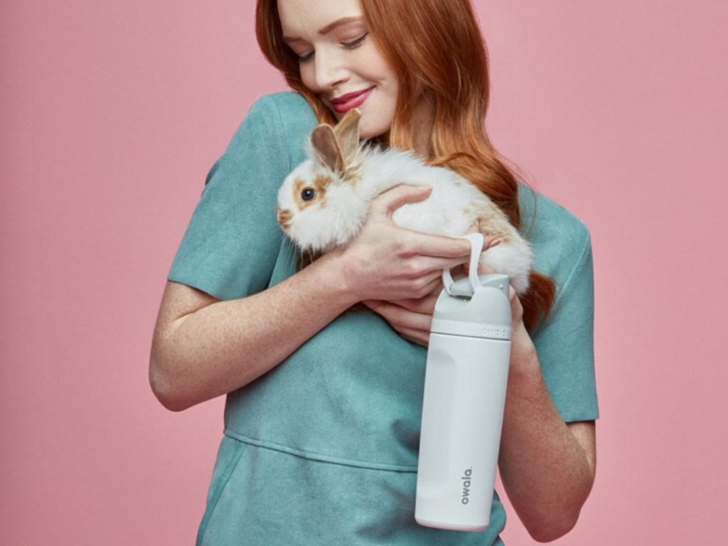 woman holding a bunny and a water bottle