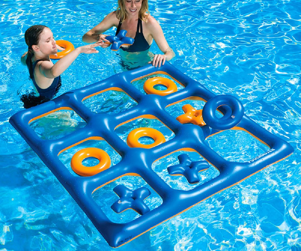 two girls playing with an inflatable tic tac toe board floating in a pool