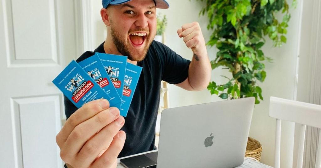 man holding Monopoly game tickets