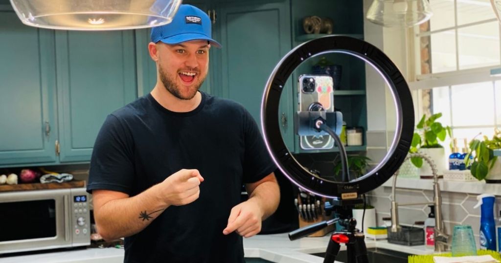 man using phone mounted to ring light