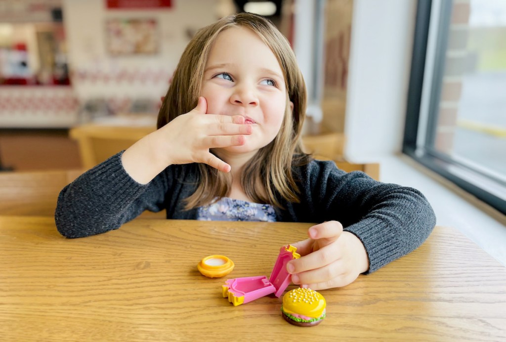 girl putting on lip balm sitting at table - April fools pranks