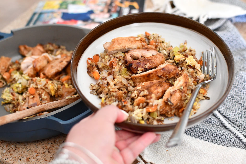 holding plate with sliced chicken and wild rice