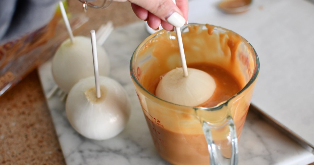 dipping an onion in caramel