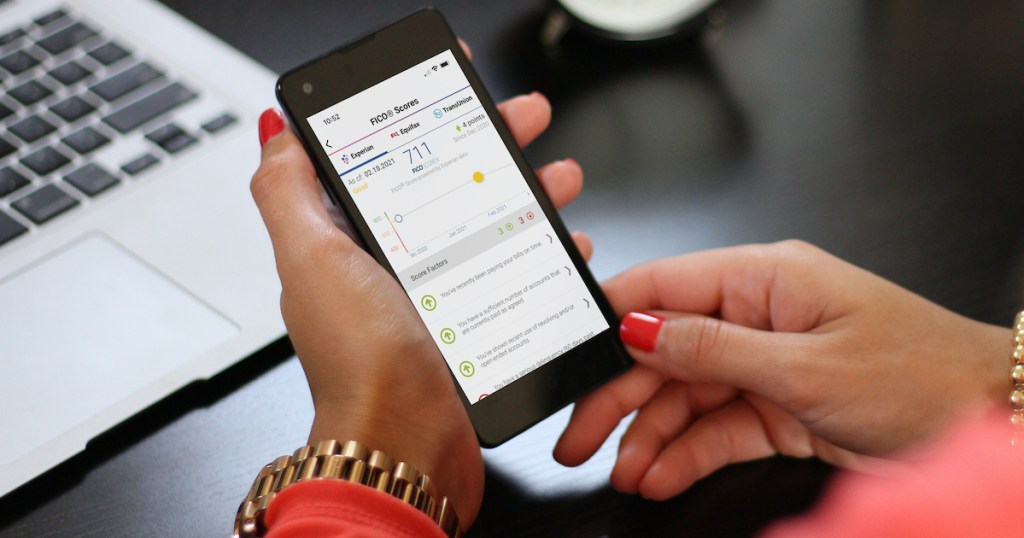 hands holding a phone with experian boost credit report on screen