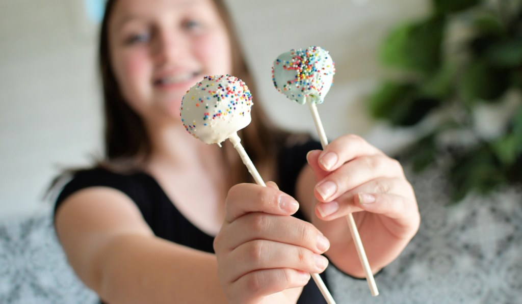 girl holding cake pops