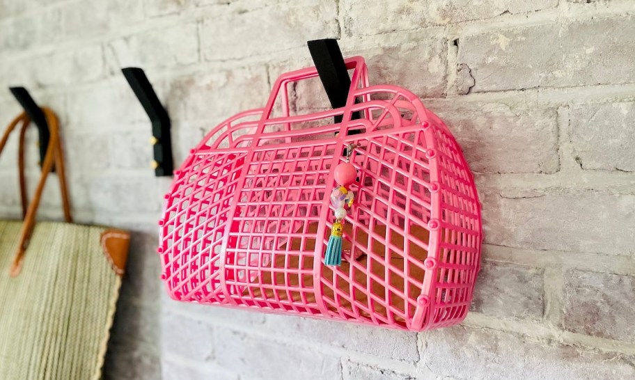 pink jelly bag hanging from hook on brick wall