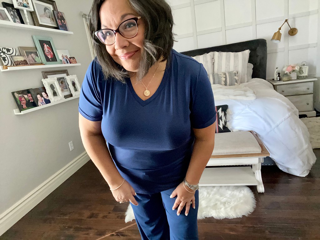 woman wearing blue pants and shirt standing in a bedroom