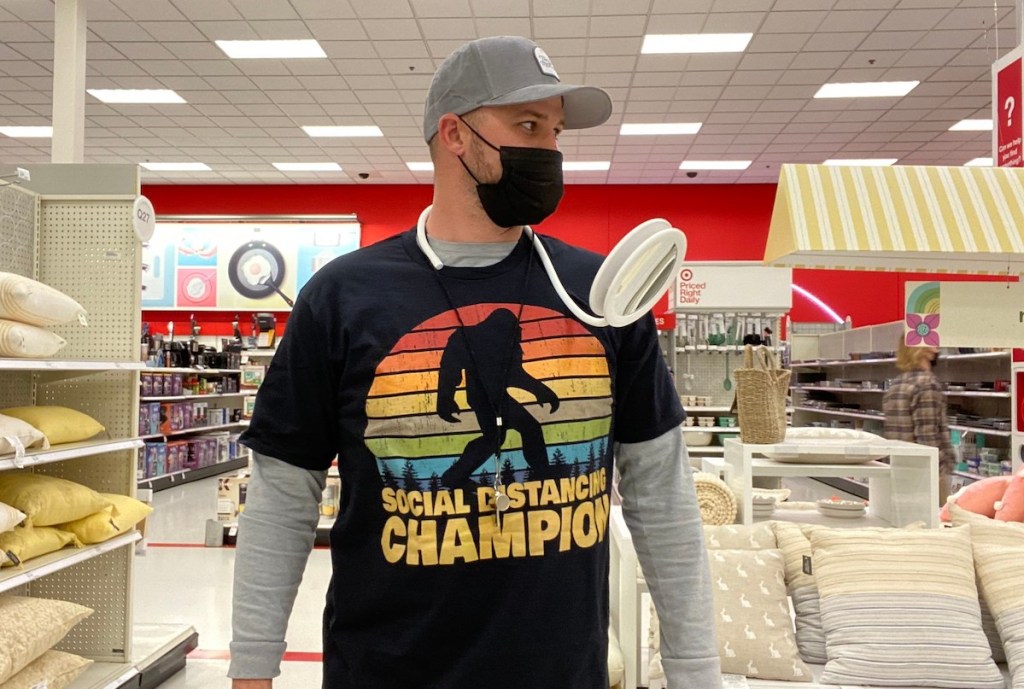 man wearing social distancing gear with mirror on shoulder at store