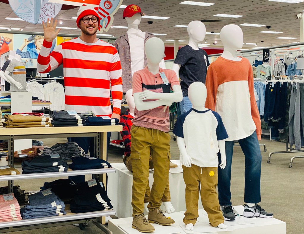 man posing with mannequins at target