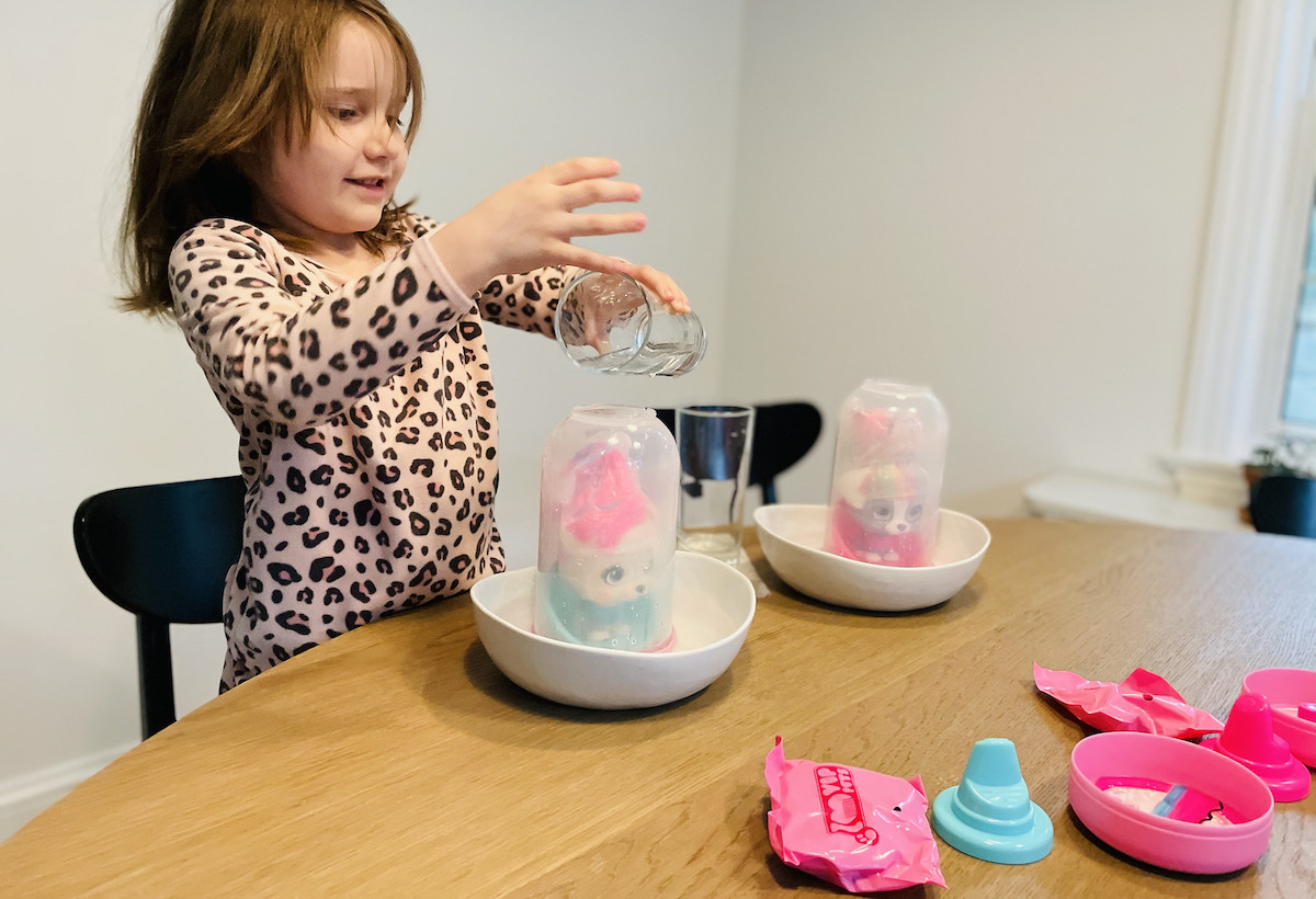 girl dumping water on surprise toy