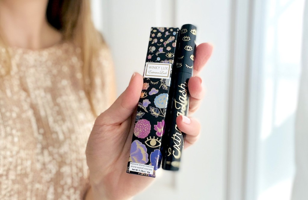 woman holding up box and tube of mascara