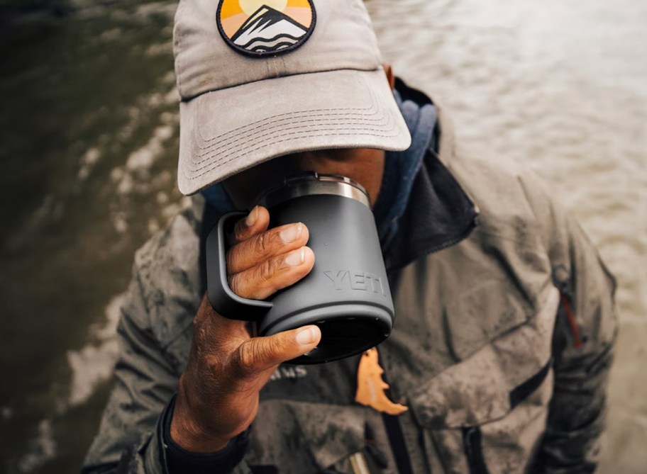 man drinking from gray blue yeti rambler with handle