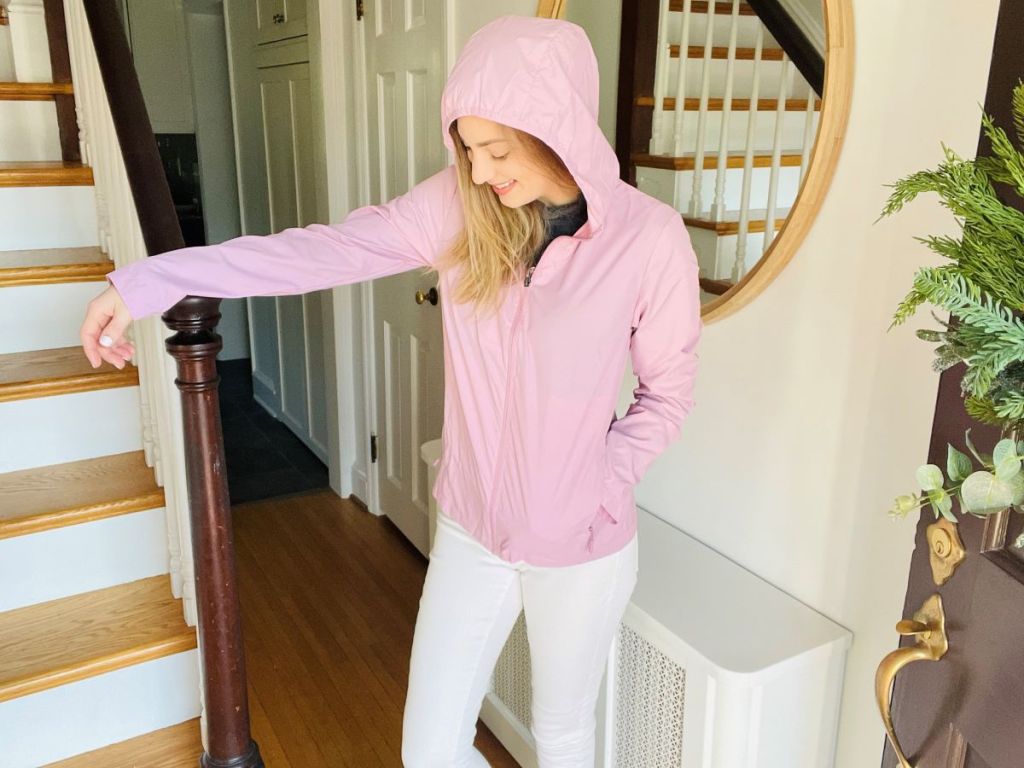 woman wearing a pink jacket standing next to stairs