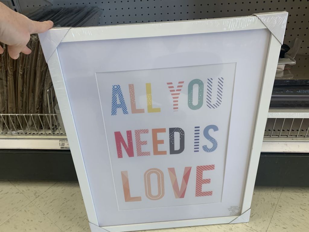 hand holding an All You Need Is Love Sign