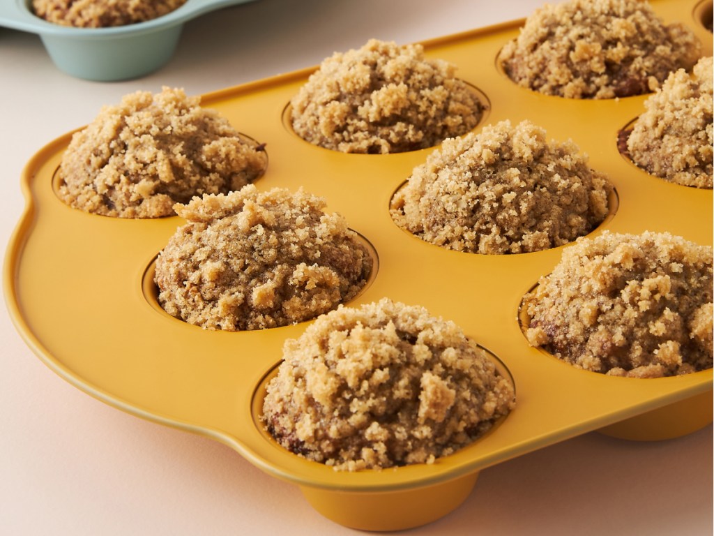 Muffin tin in orange color with muffins inside