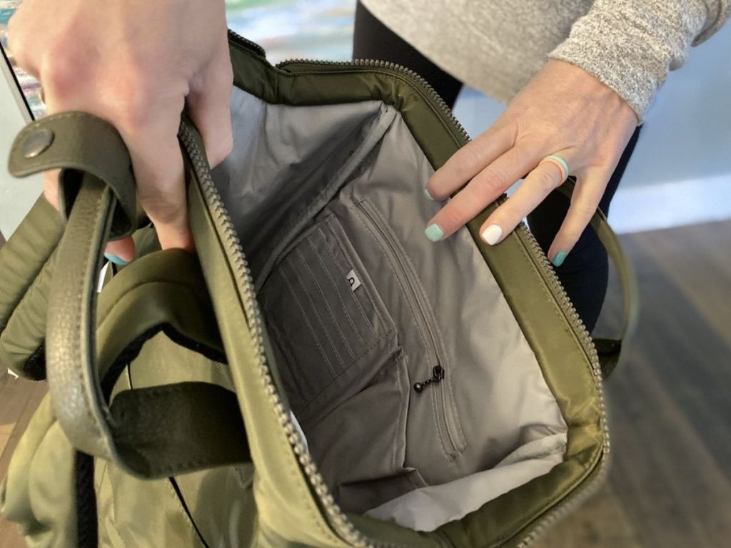 lady holding a green baggallini backpack