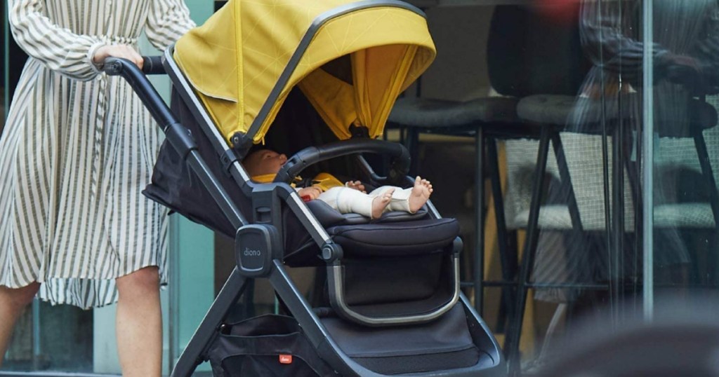 woman pushing a black and green diono quantum2 luxury stroller