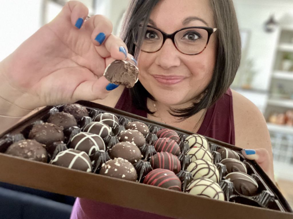 Woman holding up chocolate truffle