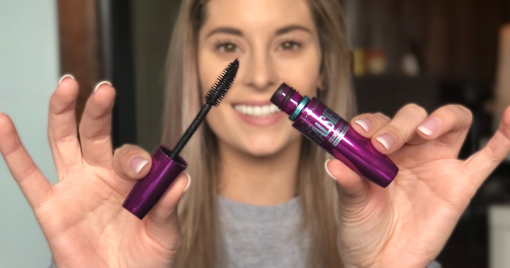 woman holding Maybelline mascara