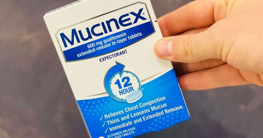 hand holding a pack of Mucinex