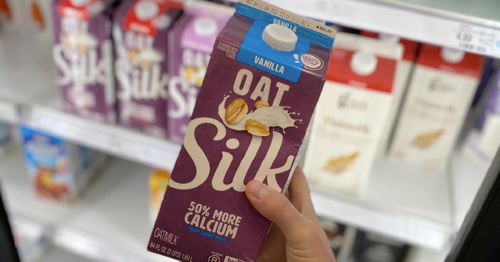 Hand holding up Oat Silk Milk in hand