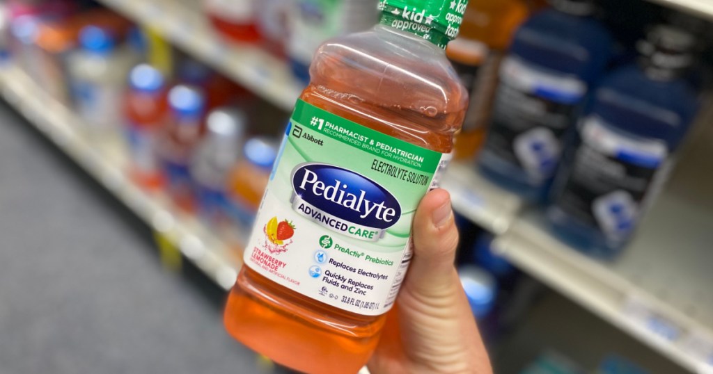 hand holding orange bottle of liquid 