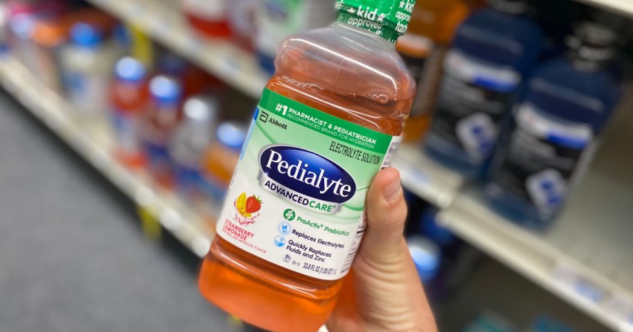 hand holding orange bottle of liquid