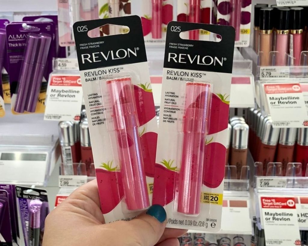 hand holding 2 Revlon Kiss Lip Balms in store