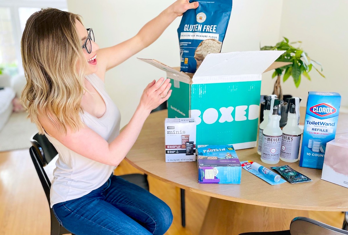 woman pulling bag of gluten free flour out of boxed order with boxed promo code