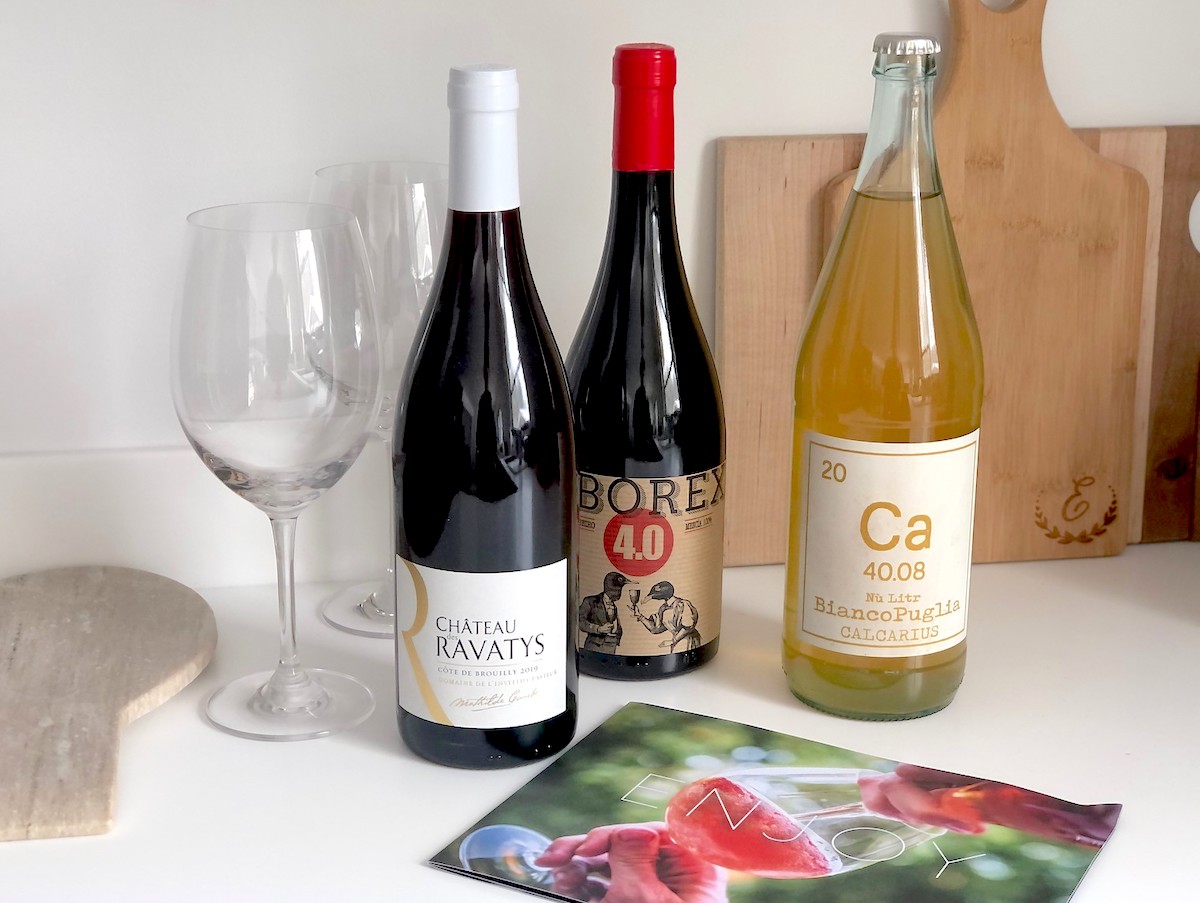 various bottles of wine and glasses on kitchen counter