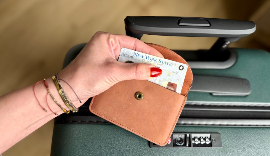 hand holding leather wallet with real id 